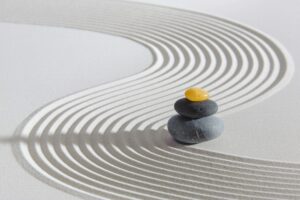 Balancing rocks with zen sand raked through depicting energy waves